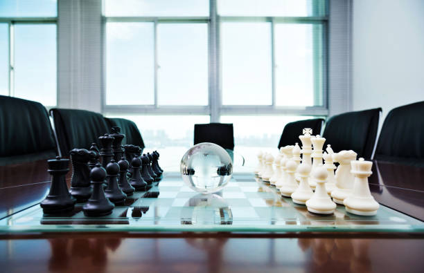 istock Chess pieces and glass earth globe on the conference table 1182850990