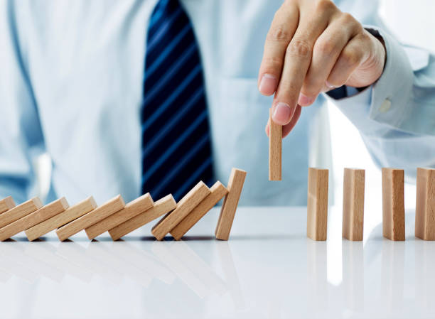 istock Businessman hand pick up one domino 1182852491