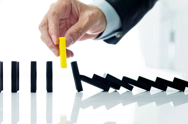 istock Businessman hand pick up one domino 1182853477