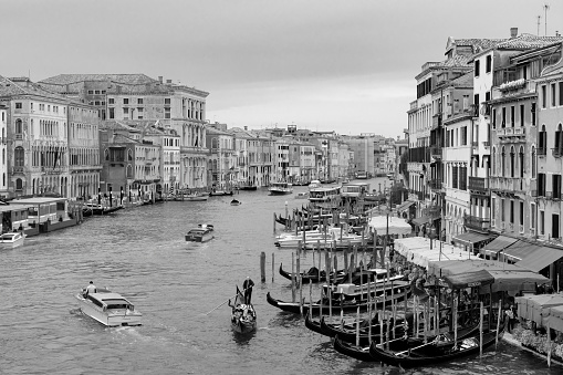 Venice, Italy - Oct, 2019: View from the Rialto Bridge of the Grand Canal in Venice. This is taken from a public access point on the bridge looking at the water taxis and gondolas on the canal on a rainy day.