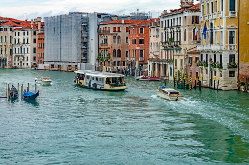 Venice, Italy - Oct, 2019: View from the Rialto Bridge of the Grand Canal in Venice. This is taken from a public access point on the bridge looking at the water taxis and gondolas on the canal on a rainy day.