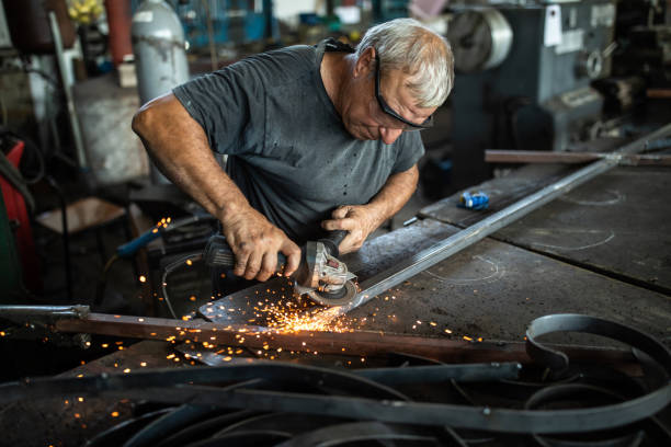 istock Manual worker grinding steel table in production hall 1182856187