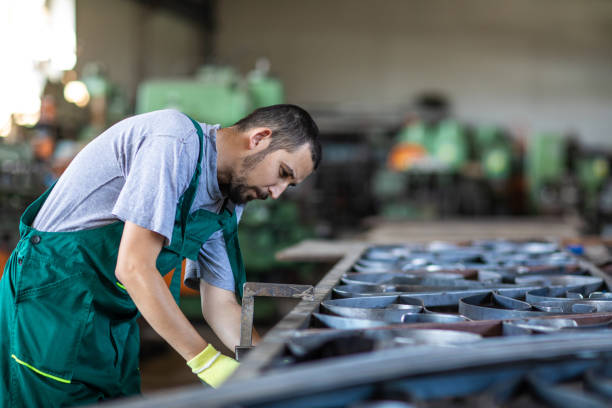 istock Young manual worker working hard in production lane 1182856260
