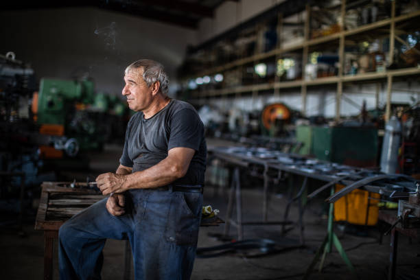 istock Mechanic resting on table in factory 1182856623