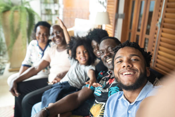 giovane che si fa un selfie della sua famiglia - riunione di famiglia foto e immagini stock