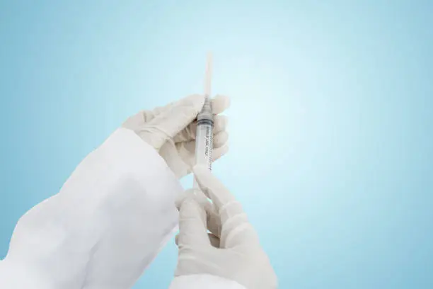 Close up of female doctor hands holding a syringe in the studio