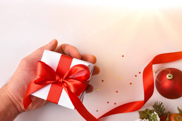 istock Hand with gift and christmas background on table top view 1182859744