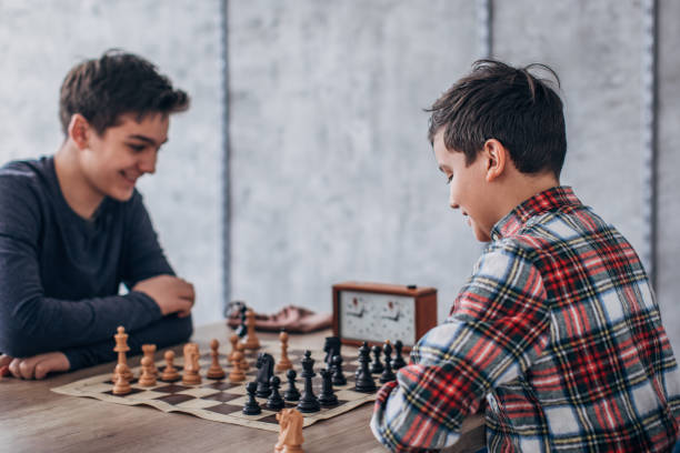 niños jugando ajedrez en la escuela de ajedrez - chess skill concentration intelligence fotografías e imágenes de stock