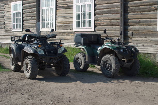 ATVs CFMoto x6 and Yamaha Grizzly 450 near the old wooden house Solovetsky islands, Russia - August 10, 2019: ATVs CFMoto and Yamaha near the wooden house 4 wheel motorbike stock pictures, royalty-free photos & images