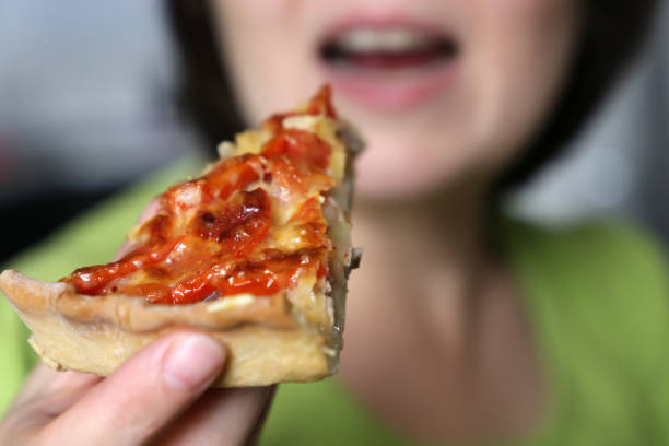 istock Girl eating and enjoying pizza 1182862054