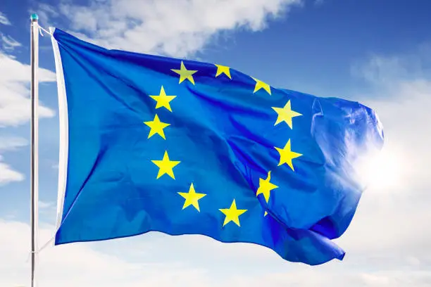 European Union flag fluttering on the flagstaff under blue sky