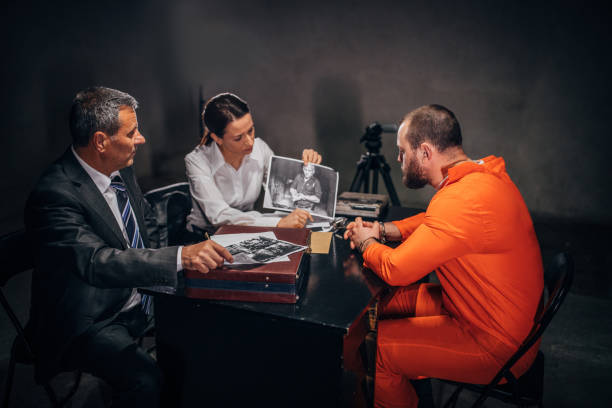 istock Two detectives and prisoner in investigation room 1182865046