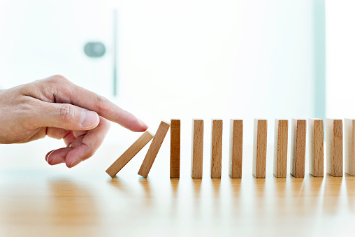 Man hand pushing domino pieces