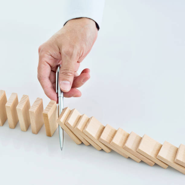 istock Businessman hand holding a pen stop domino effect 1182865451
