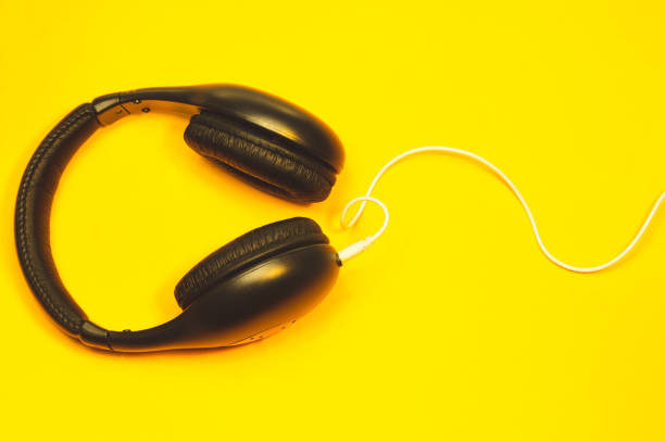 istock Headphones with white cable on a yellow background 1182868698