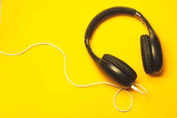 istock Headphones with white cable on a yellow background 1182868757