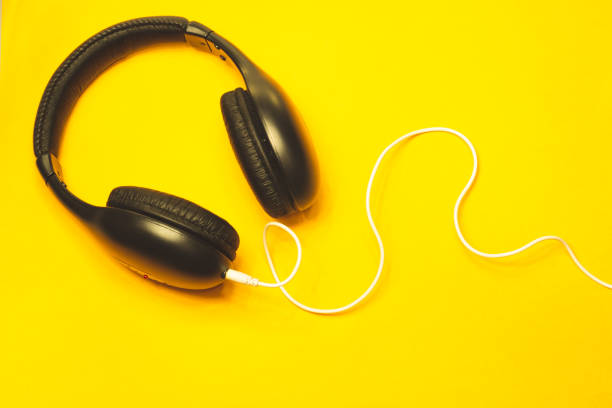 Headphones with white cable on a yellow background
