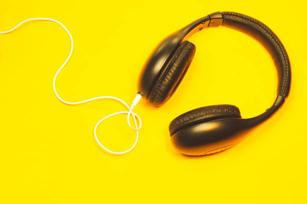 istock Headphones with white cable on a yellow background 1182868818