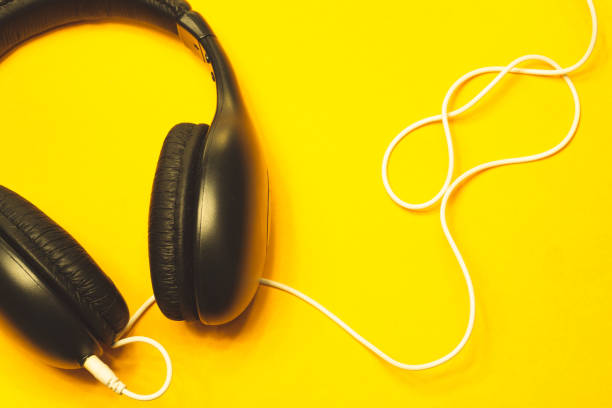 istock Headphones with white cable on a yellow background 1182868935