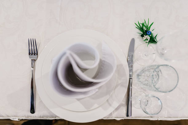 istock Serving, setting table. Two plates and silverware cutlery linen napkin and branch greens. Wedding table decoration. Artwork. flat lay. top view. Close up. 1182869007