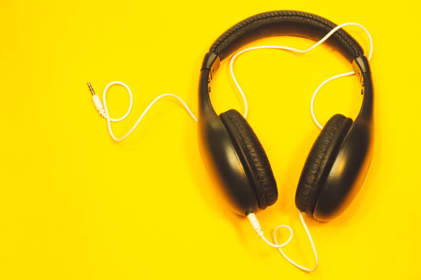 istock Headphones with white cable on a yellow background 1182869217
