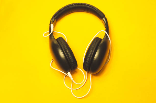 istock Headphones with white cable on a yellow background 1182869883