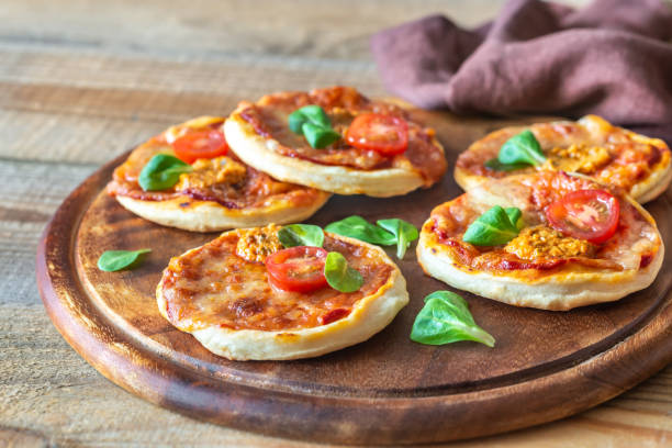 istock Mini pizzas on the wooden board 1182870559