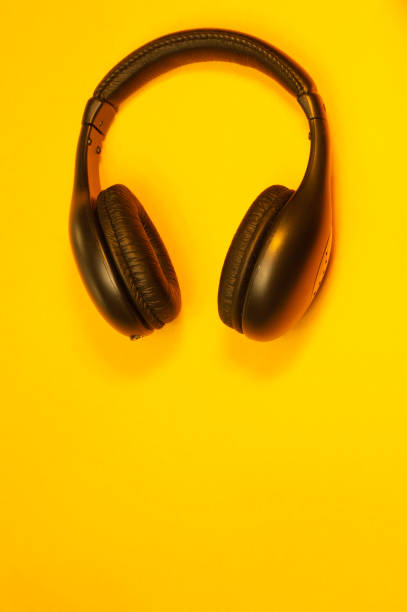 istock Black wireless headphones on a yellow background 1182871877