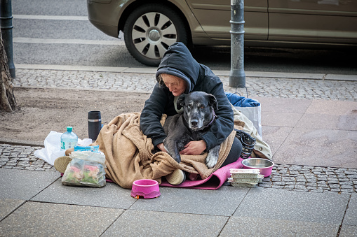 Tauentzien Strasse, Central Berlin, Germany, September 19, 2019: Old lady with a dog begging for money in the middle of the German capital Berlin