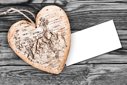 Wooden heart against vintage board with label