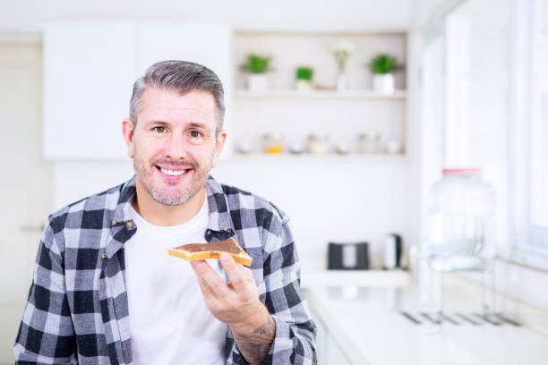 istock Happy Caucasian man eating breakfast in kitchen 1182877782