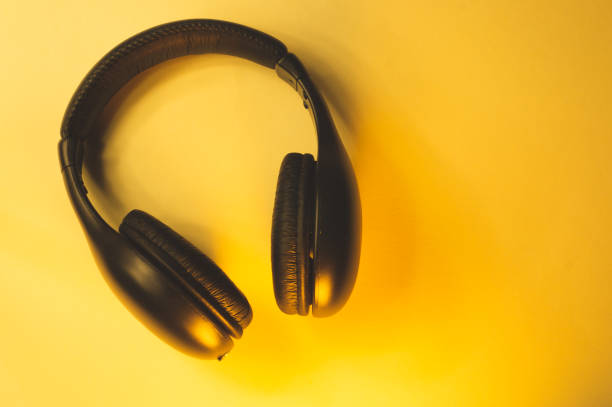 istock Black wireless headphones on a yellow background 1182878031