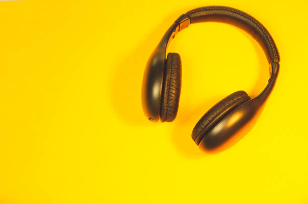 istock Black wireless headphones on a yellow background 1182878049