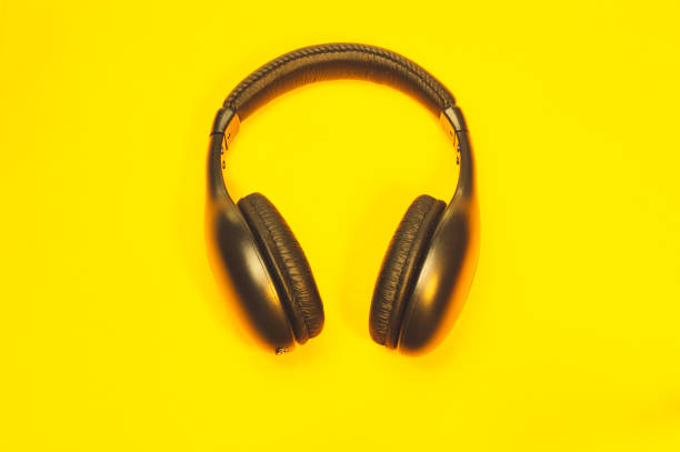istock Black wireless headphones on a yellow background 1182878081
