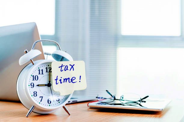 istock A clock with tax time sticky note on office table 1182878095
