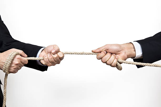 istock Two business people pulling rope in tug of war on white 118288103