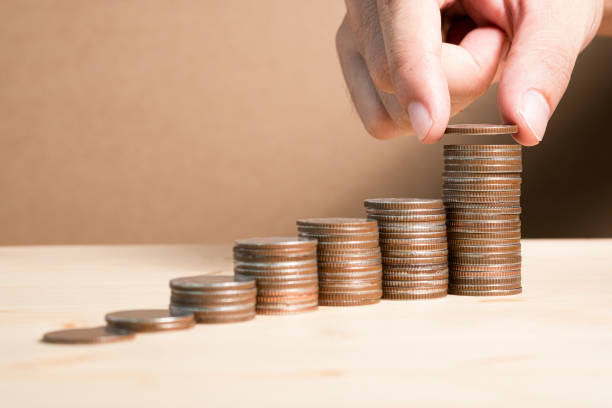 istock Hand putting coins stacking for saving in the future and fund stock value investment. 1182884258
