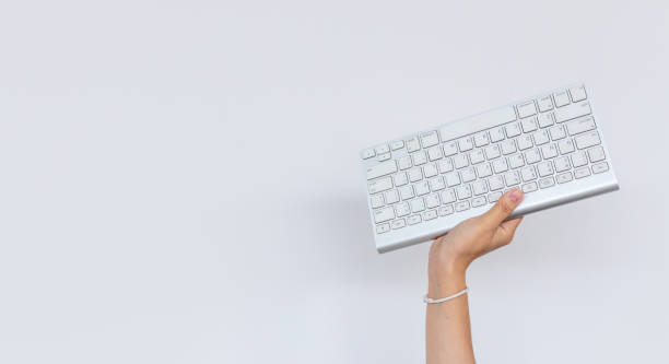 istock business, work hard concept. hand holding keyboard computer with on white background 1182884515