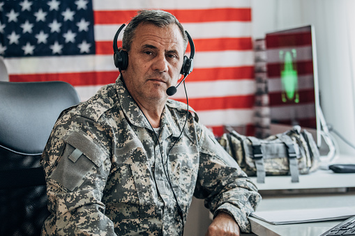 Army solider working in the office and writing on some papers