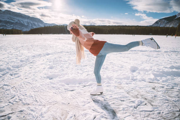 młoda kobieta na łyżwach na zamarzniętym jeziorze o zachodzie słońca zabawy i korzystających z zimowych wakacji - snowshoeing snowshoe women shoe zdjęcia i obrazy z banku zdjęć