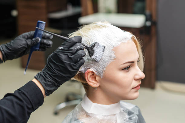 Close up of hands in black gloves are applying white color to woman hair. Close up of hands in black gloves are applying white color to woman hair. Hair coloring in white color at beauty salon. People and beauty concept. bleach stock pictures, royalty-free photos & images