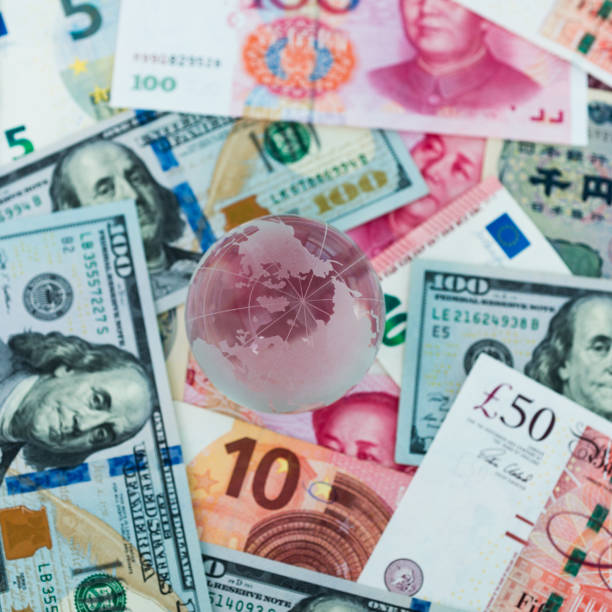 istock Glass globe and international currency notes 1182888734