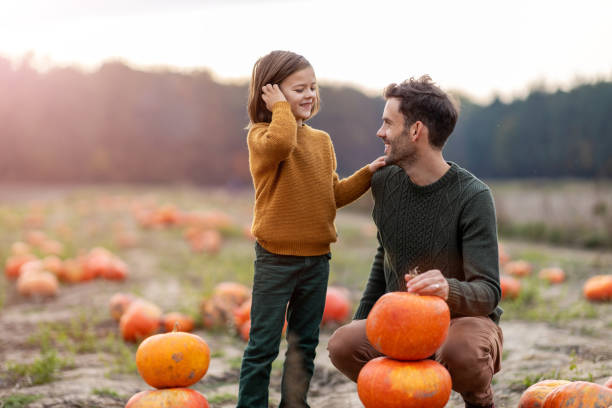 istock Father and son in pumpkin patch field 1182889436