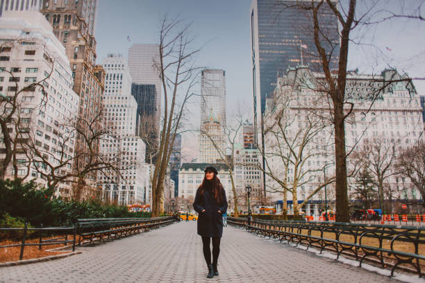 giovane donna che cammina nel parco centrale di new york in inverno - new york city new york state skyline winter foto e immagini stock