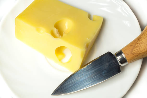 istock Cheese with a cheese knife on a white plate 1182890369