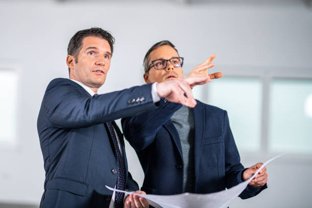 istock Real estate agent and businessman checking plans in an empty office 1182890585