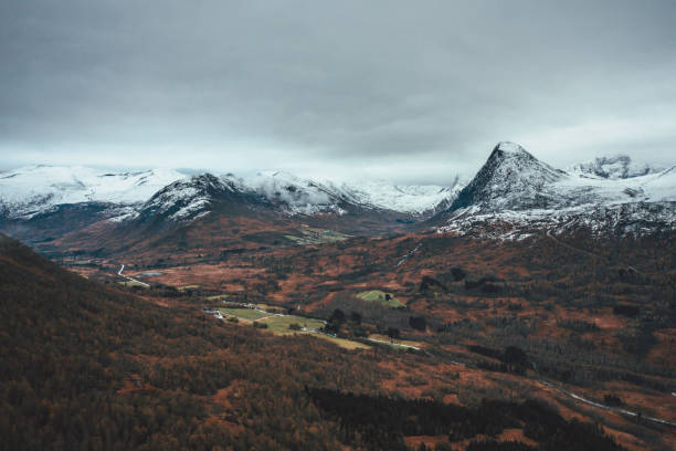 Misty norwegian landscape view on a dark morning with mountains and forests