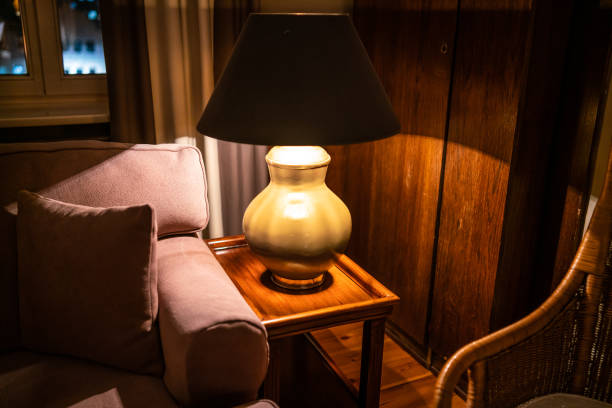 istock Lamp on a night table next to a bed 1182901566