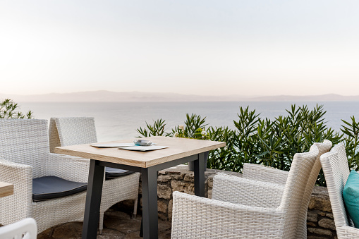 wicker chairs and tables in a summer cafe with sea views. Restaurant sea terrace