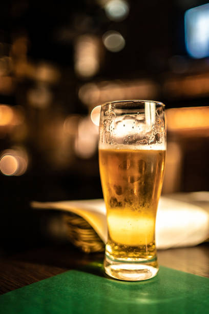 istock cold beer glass on bar or pub desk 1182901624